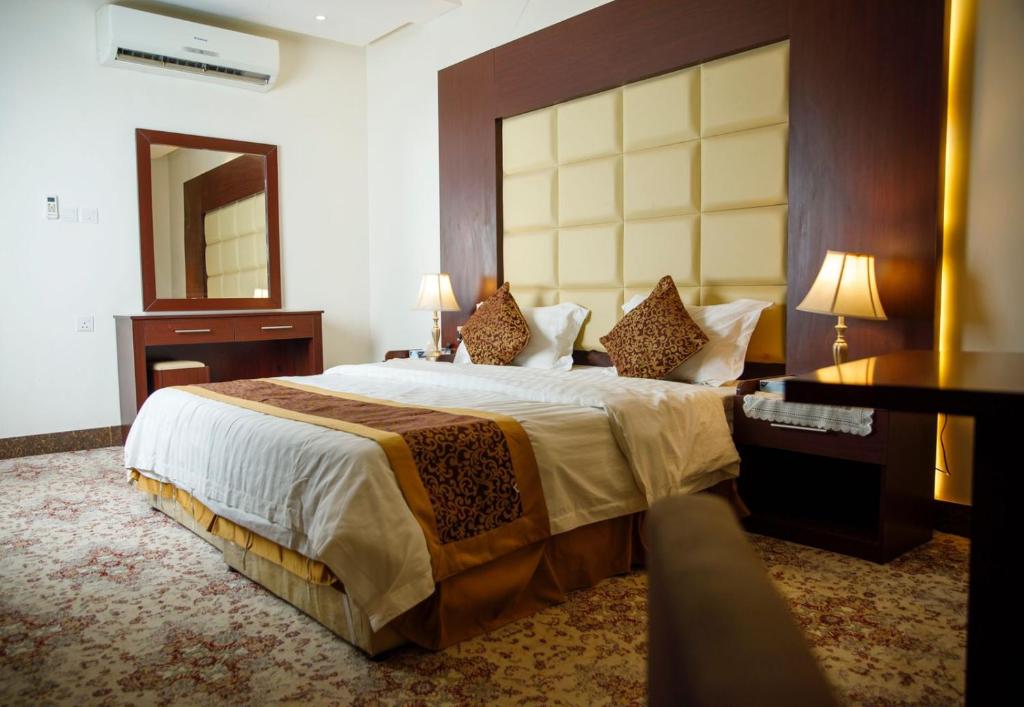 a hotel room with a large bed and a desk at غالينا للوحدات السكنية in Abū Qa‘ar