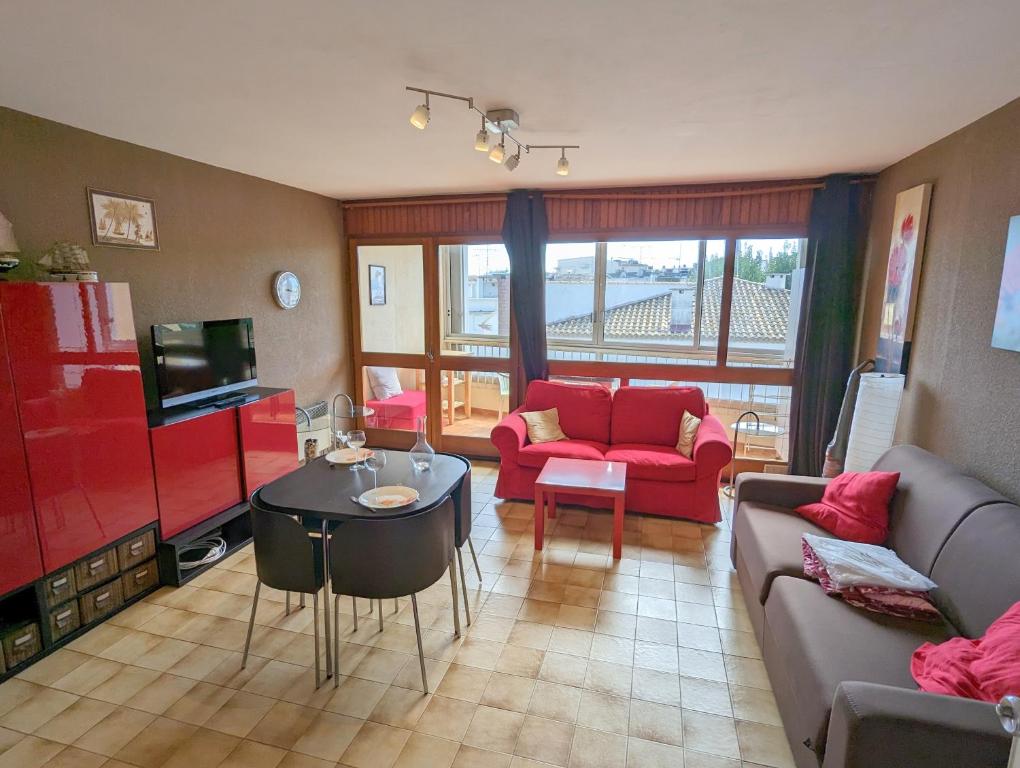 uma sala de estar com um sofá e uma mesa em Sol-y-Days Murènes, Grand studio confortable avec parking, proche du centre ville et de la plage em Le Grau-du-Roi
