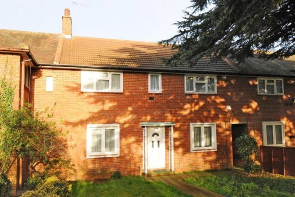 a red brick house with a white door at Spacious 3-Bed House with car park near Heathrow in Hounslow