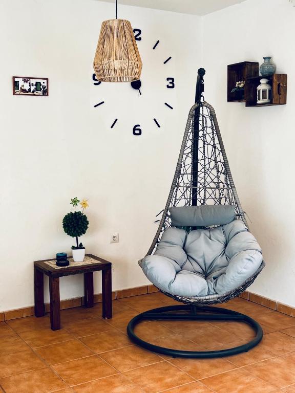 Pokój z huśtawką i zegarem na ścianie w obiekcie Casita A Pitisa w mieście Playa Blanca