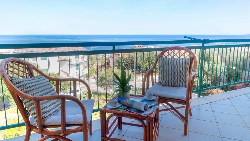 two chairs and a plant on a balcony at Sea view balcony in Cala Gonone
