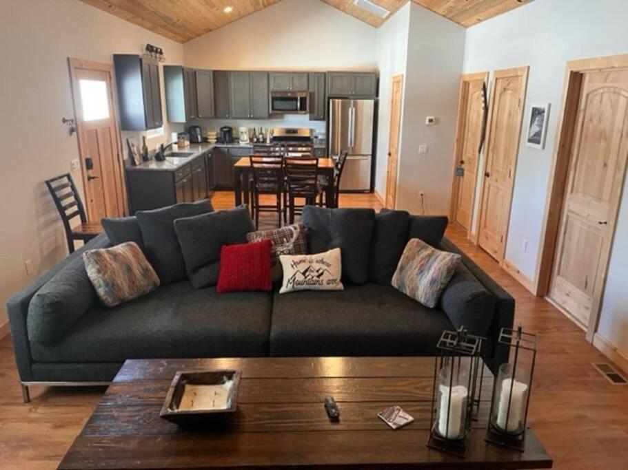 a living room with a couch and a kitchen at Compass Rose Colorado in Pagosa Springs