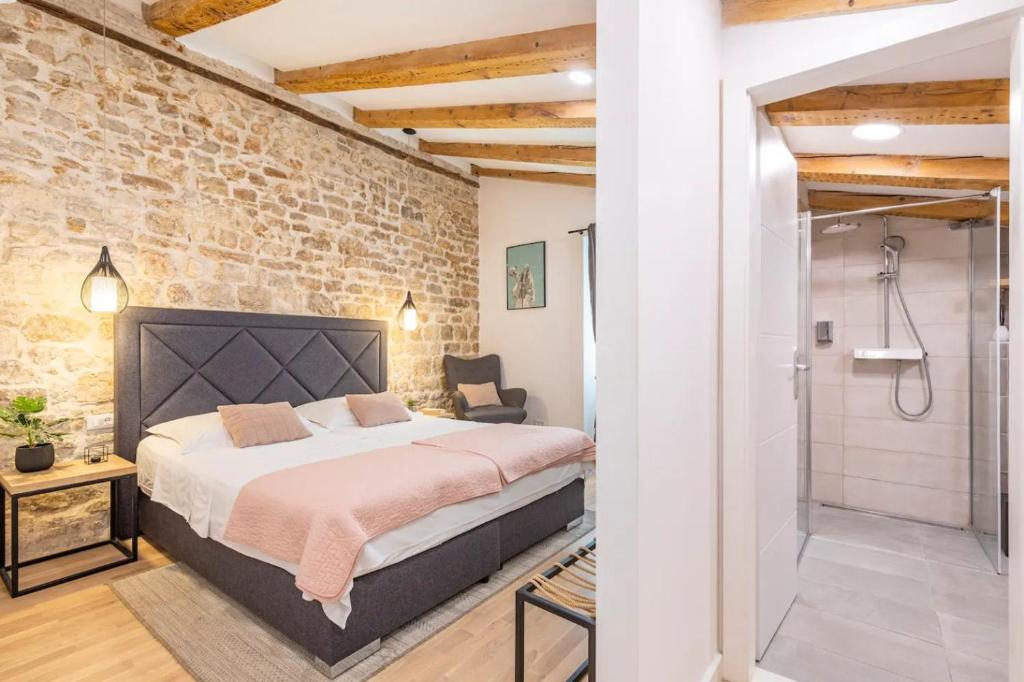 um quarto com uma cama e uma parede de tijolos em Luxury rooms Prestige Palace em Split