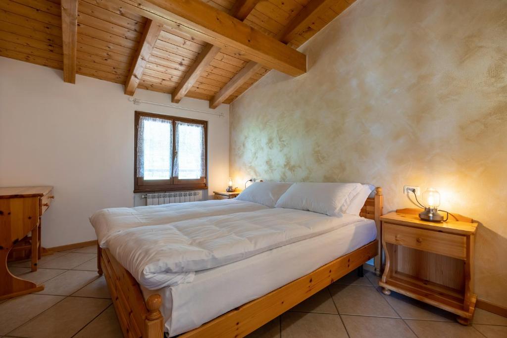 - une chambre avec un lit dans une pièce dotée de plafonds en bois dans l'établissement Agriturismo Val d' Egoi 3, à Tremosine