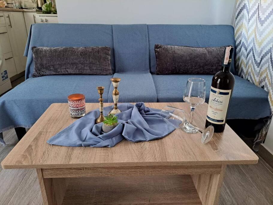una mesa con una botella de vino y una copa de vino en Lydia's cozy house en Paradeísion