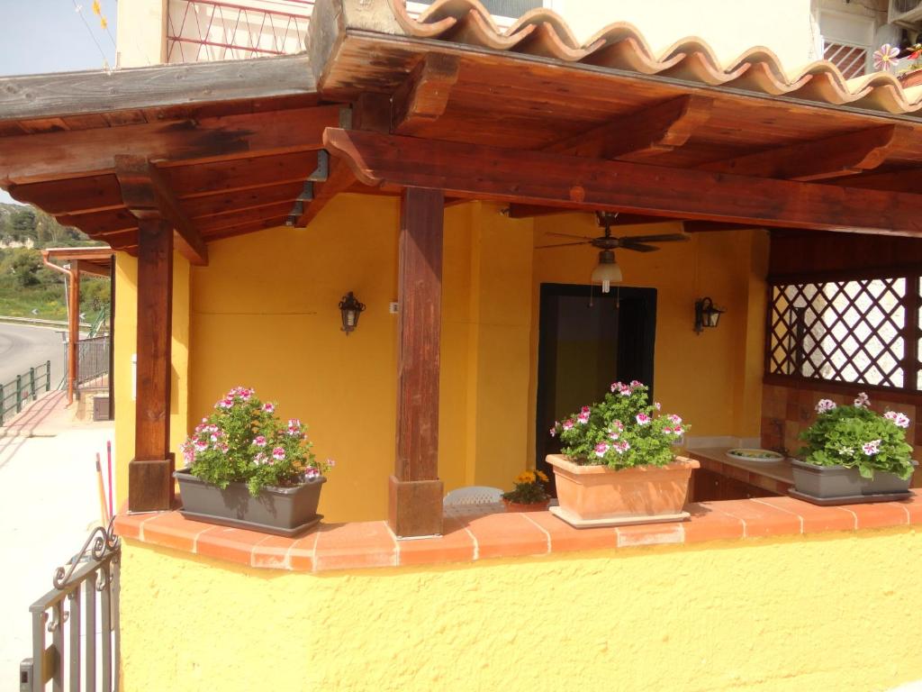 a house with three potted plants on the side of it at Baciati Dal Sole in Porto Empedocle