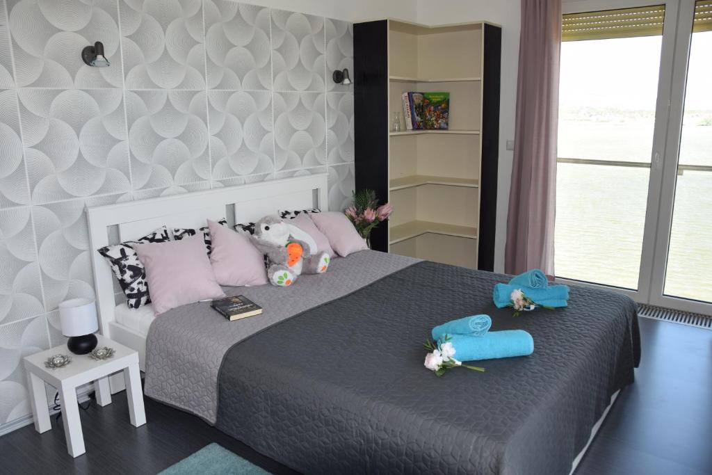 a bedroom with a large bed with pink pillows at Panorama Apartman in Velence