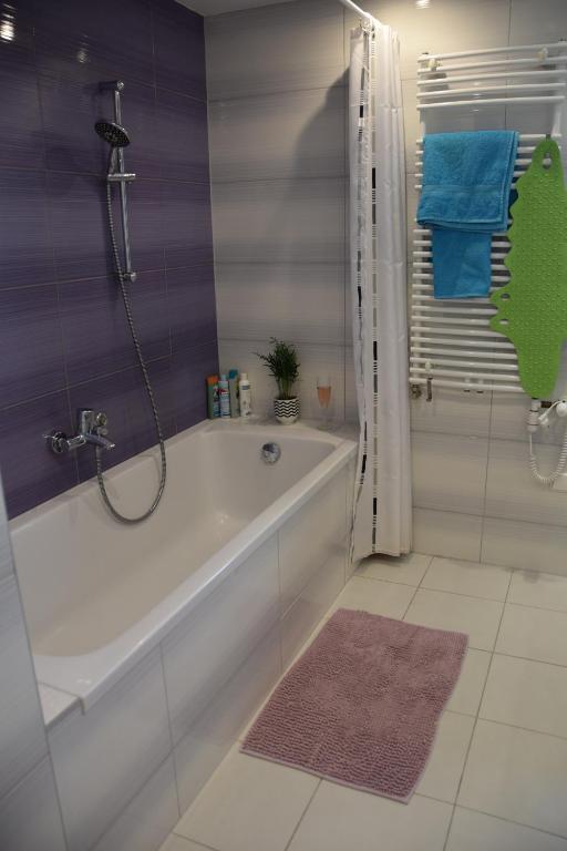 a white bathroom with a tub and a shower at Panorama Apartman in Velence