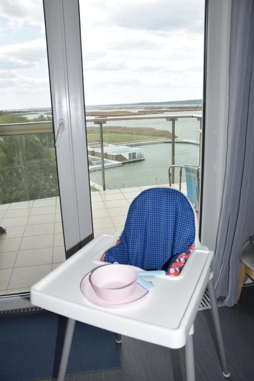 a white chair with a pink plate on a balcony at Panorama Apartman in Velence