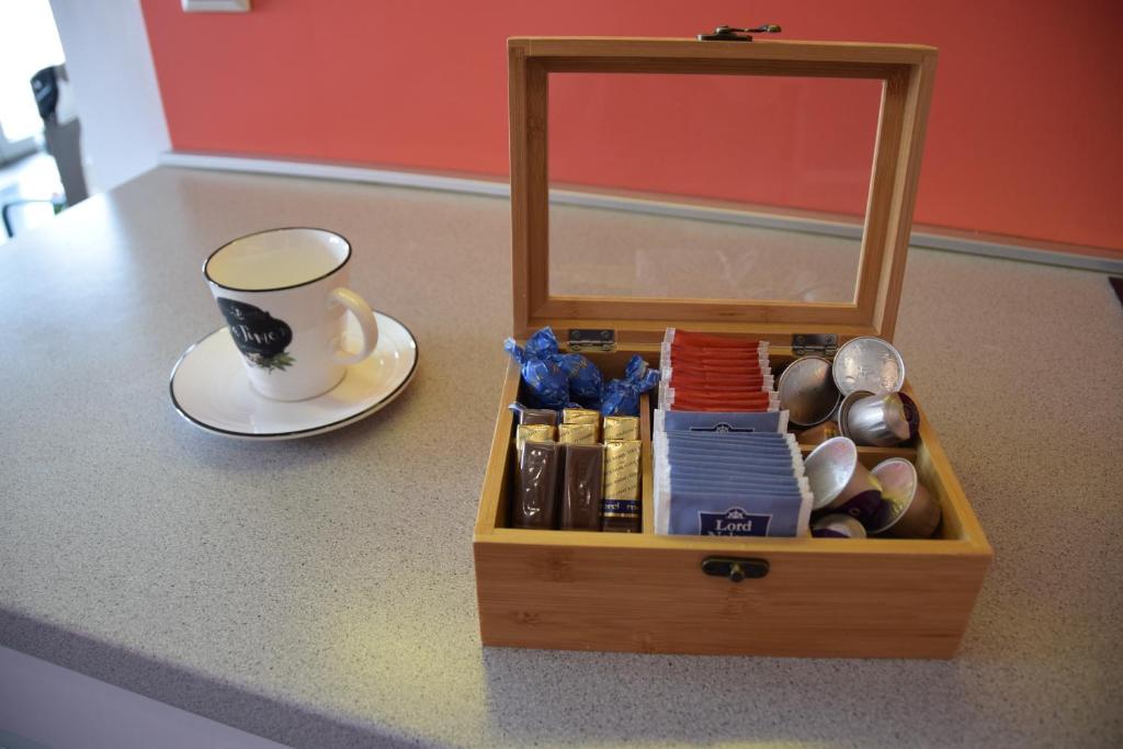 a wooden box with a cup of coffee and a plate at Panorama Apartman in Velence