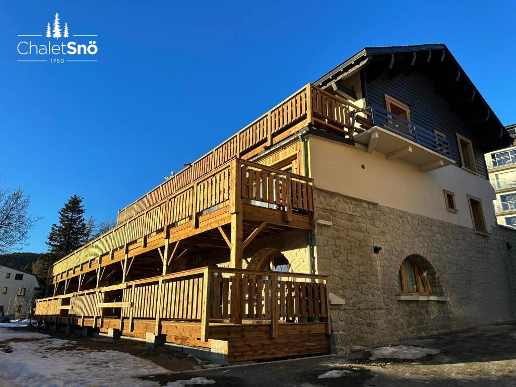 a building with a deck on the side of it at Chalet Snö 1750 in Font Romeu Odeillo Via