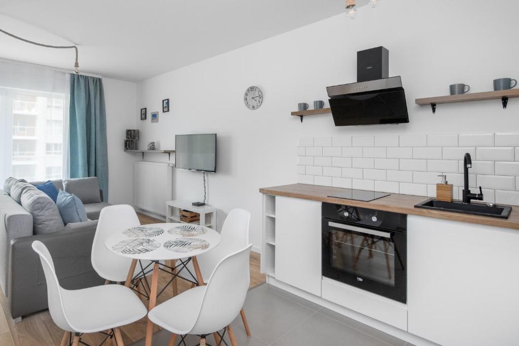 a kitchen and living room with a table and chairs at FALE BAŁTYKU in Gdańsk