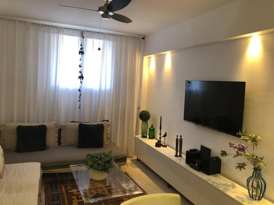 een woonkamer met een bank en een flatscreen-tv bij The excellent home in Athene