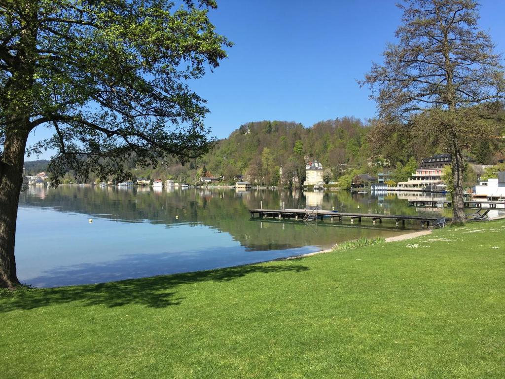 a view of a lake with a dock at See & You Ferienwohnung mit Hotelanbindung in Pörtschach am Wörthersee