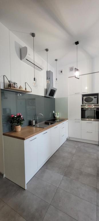 a kitchen with white cabinets and a counter top at Apartament 39 in Lublin
