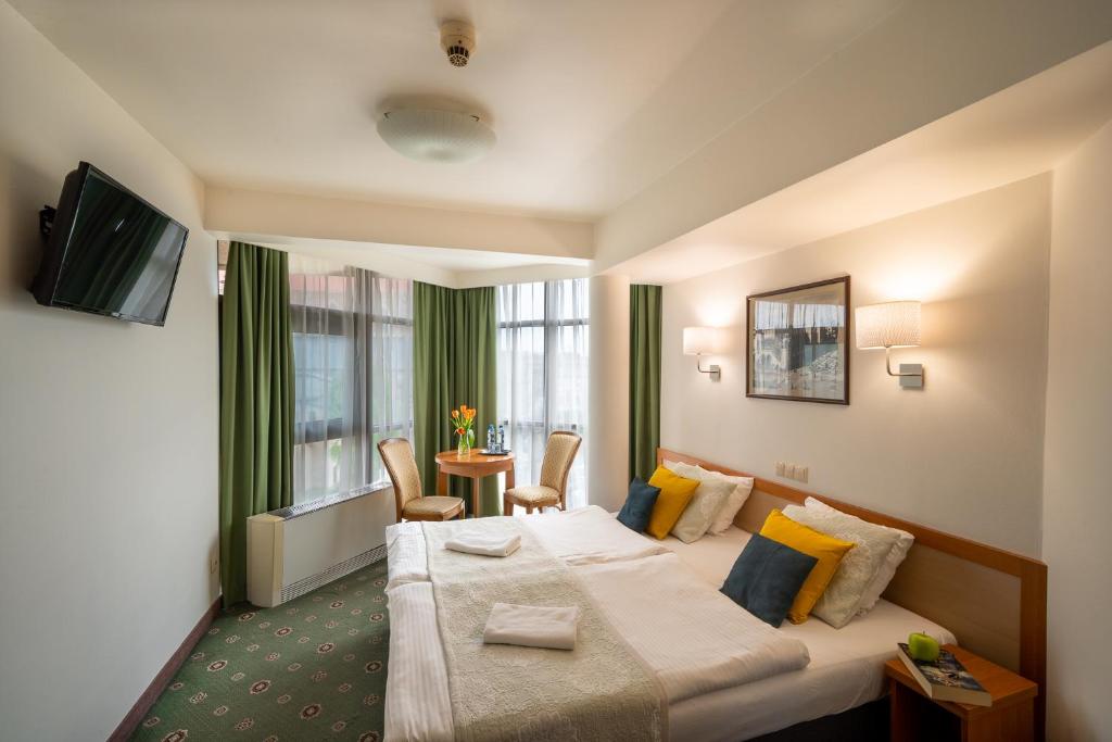 ein Hotelzimmer mit einem großen Bett und einem Tisch in der Unterkunft Hotel Secesja in Krakau