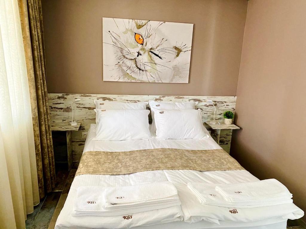1 dormitorio con 1 cama con sábanas y almohadas blancas en Kiki Home en Blagoevgrad