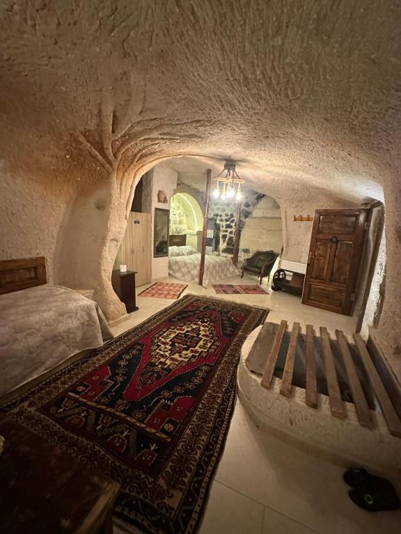 una camera con un letto, un divano e un tappeto di Uchisar Cave House a Üçhisar