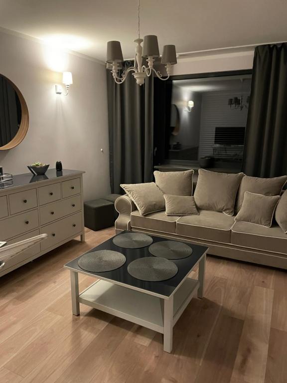 ein Wohnzimmer mit einem Sofa und einem Tisch in der Unterkunft Przy Błoniach in Stettin
