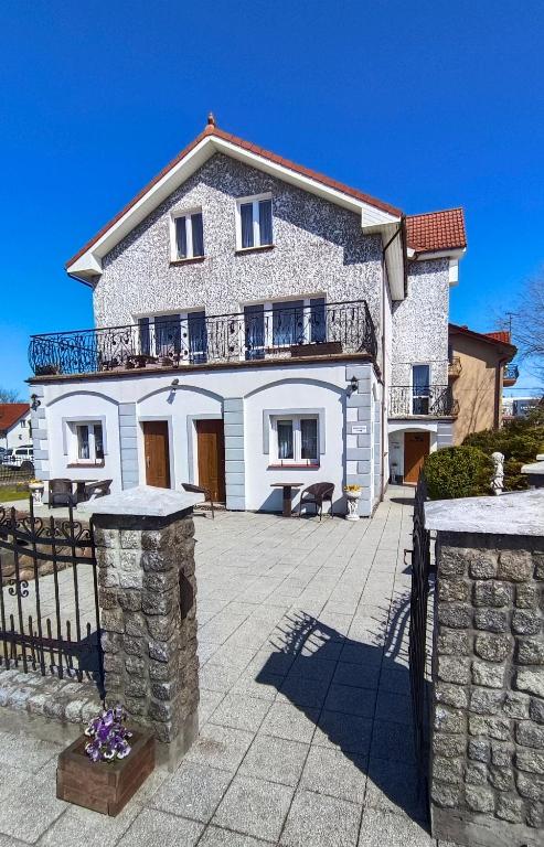 a large white house with a fence in front of it at Marszałek Mielno in Mielno