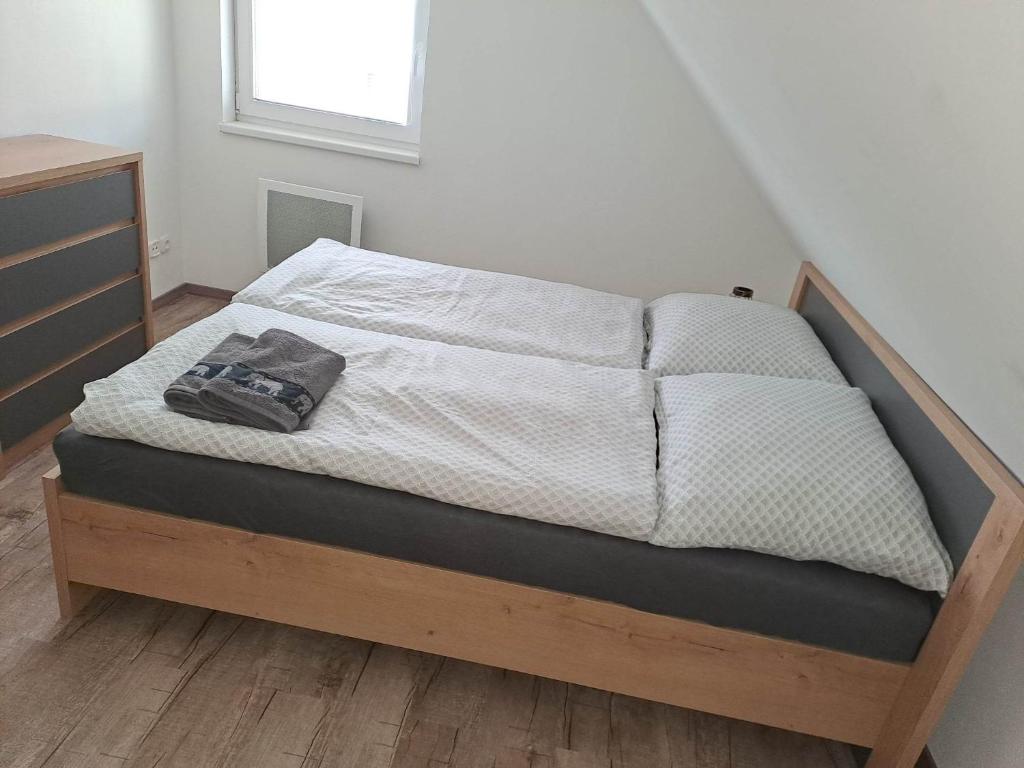 a bed with a wooden frame in a bedroom at Chata Štíty in Štíty