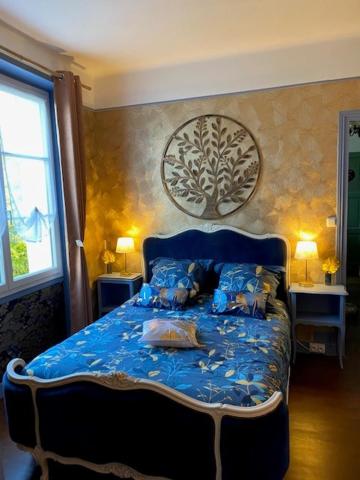 a bedroom with a blue bed with pillows on it at Le Moulin du Modon in Couffy