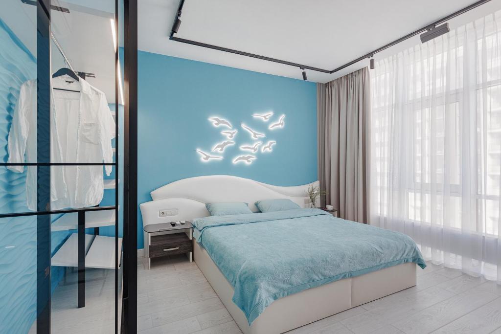 um quarto com uma cama e uma parede azul em THE BEST APARTMENT ON THE SEASIDE IN ODESA! Luxury apartments in Arcadia, near seaside! em Odessa