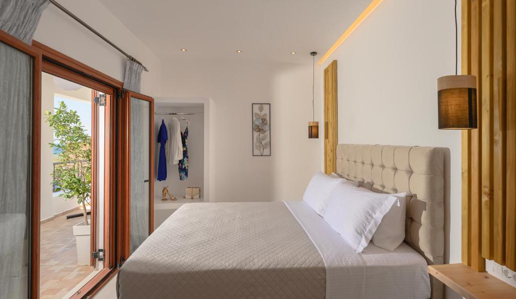 a bedroom with a large bed and a sliding glass door at Auster House Santorini in Kamari