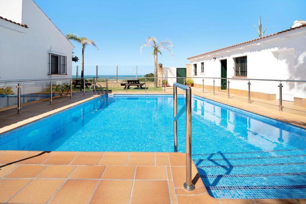 a swimming pool with a view of the ocean at Novobarrosa D in Chiclana de la Frontera