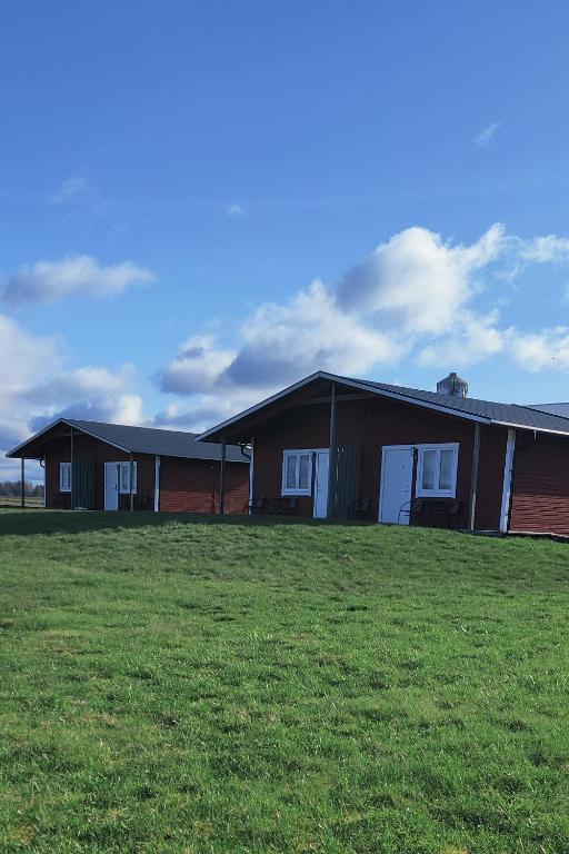 un grupo de edificios con un campo de césped delante en Stuga utanför Skövde 1, en Skövde
