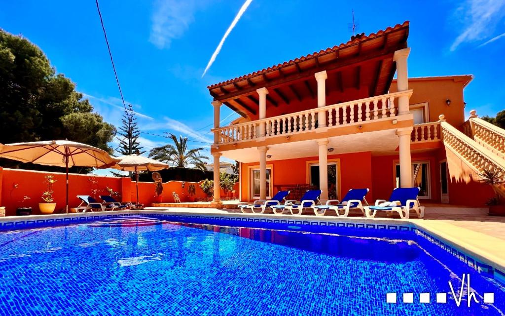 a villa with a swimming pool in front of a house at VH CostaBlanca - CARRASQUETA in Moraira
