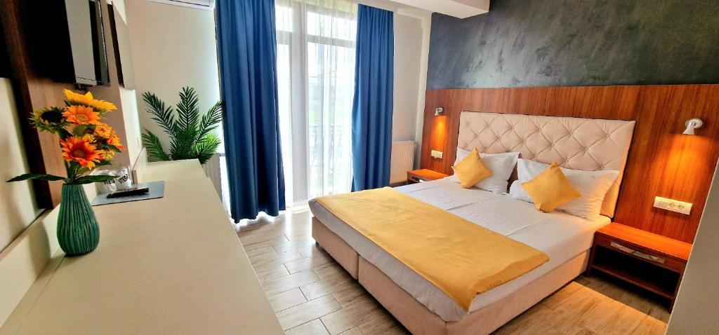 - une chambre avec un lit et un vase de fleurs dans l'établissement Summer Love, à Mangalia