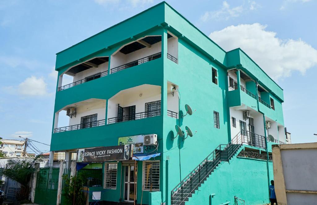 un edificio blu e bianco con balcone di L'IMMEUBLE QUEEN M.N.M a Douala