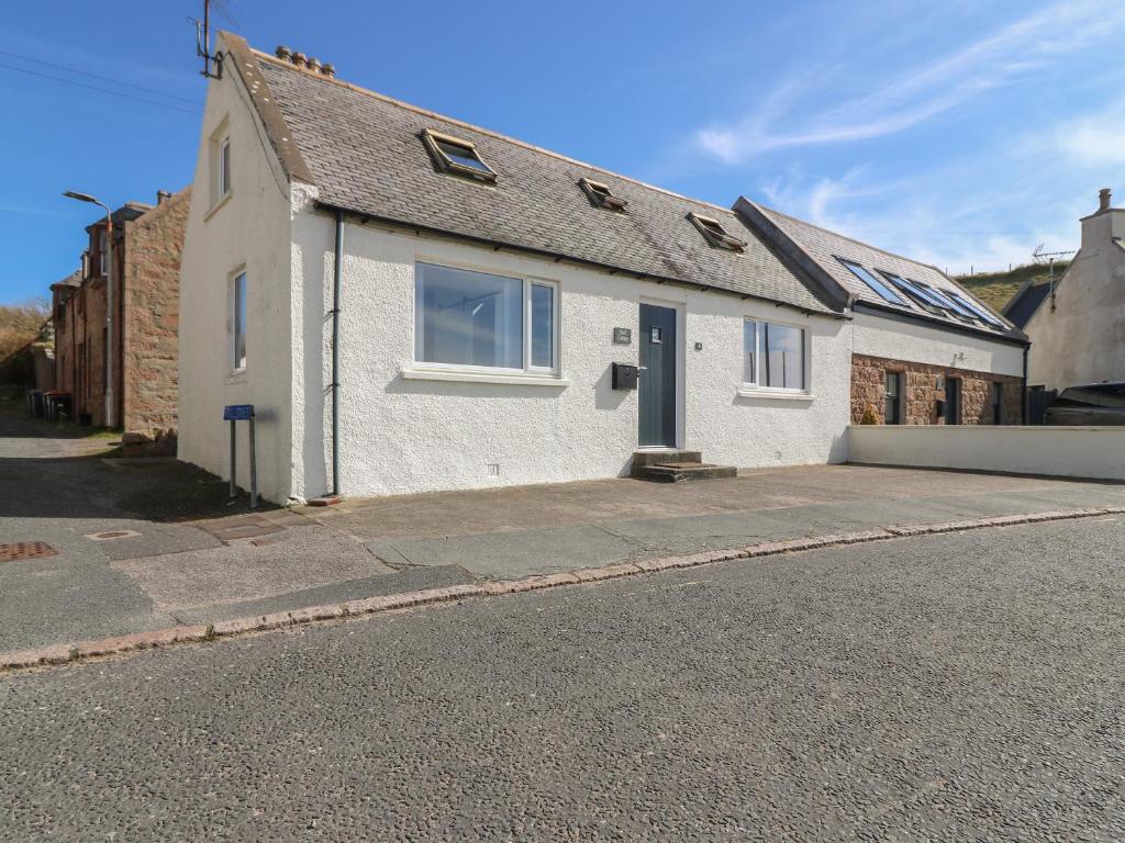 a white house on the side of a street at Shell Cottage in Peterhead