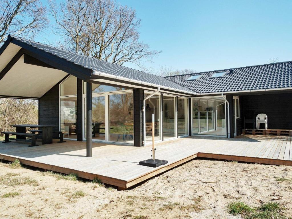 a house with a solar roof on a wooden deck at Holiday home Hundested XI in Hundested