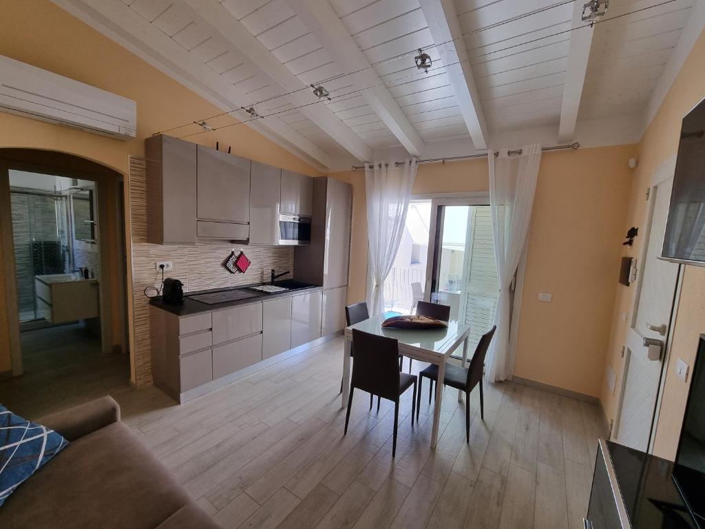 cocina y sala de estar con mesa y sillas en Appartamento Spargi en Isola Rossa