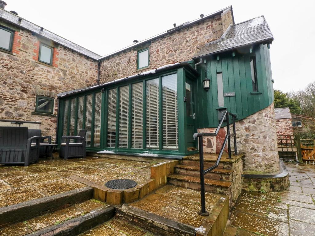 una casa con una porta verde e alcune scale di Skomer Cottage a Haverfordwest