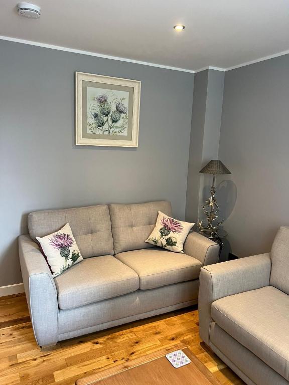 a living room with a couch and a table at Inverness Highland Apartment in Inverness