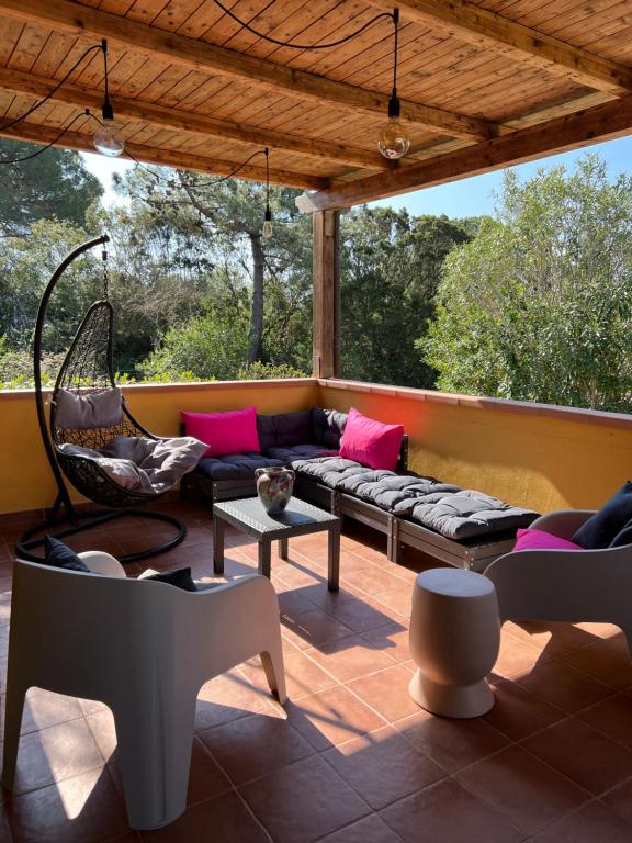 a screened in porch with a couch and chairs at Villetta Lampone in Lacona