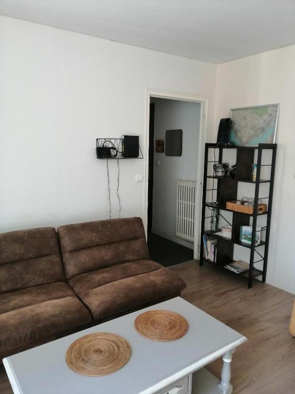 a living room with a couch and a coffee table at Beau Studio proche front de mer , place de parking, fibre in Saint-Nazaire