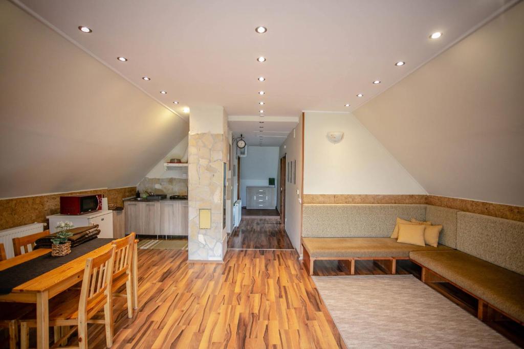 LiBe Apartman في جينيسدياس: غرفة معيشة مع أرضيات خشبية ودرج