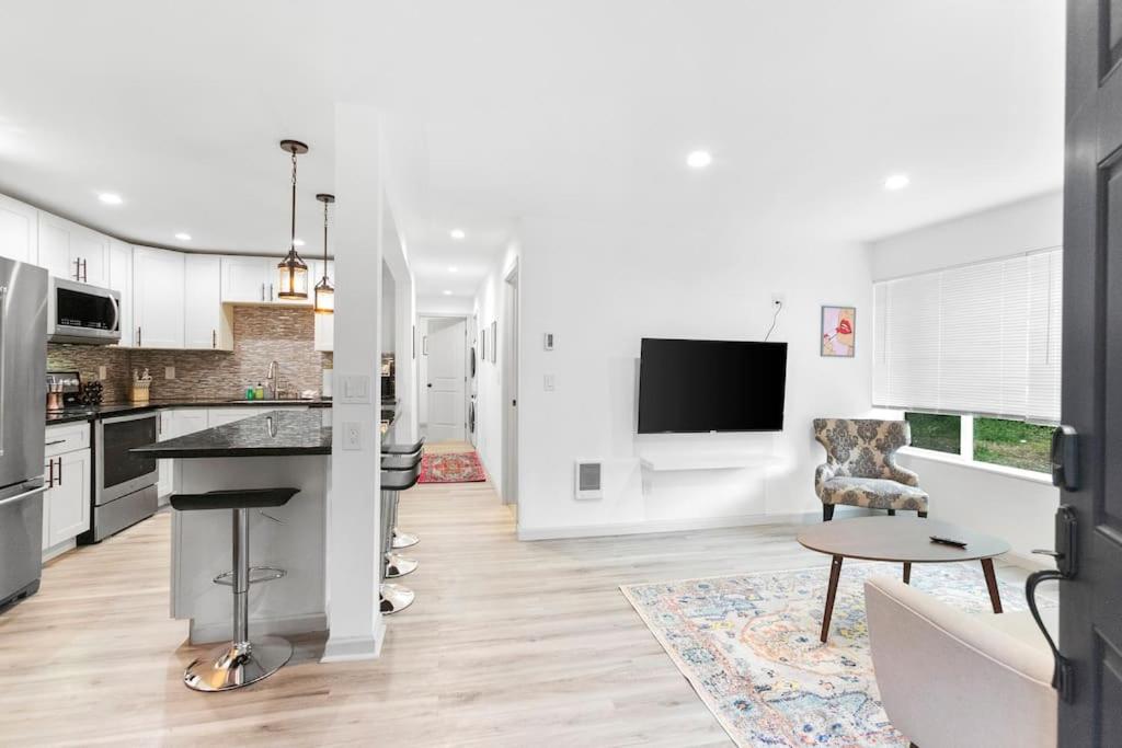 a kitchen with white cabinets and a living room at Hillside in Seattle - updated and well appointed. in Seattle