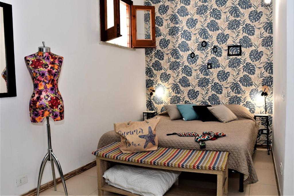 a bedroom with a bed and a dress hanging on a wall at Villa Maria in San Vito lo Capo