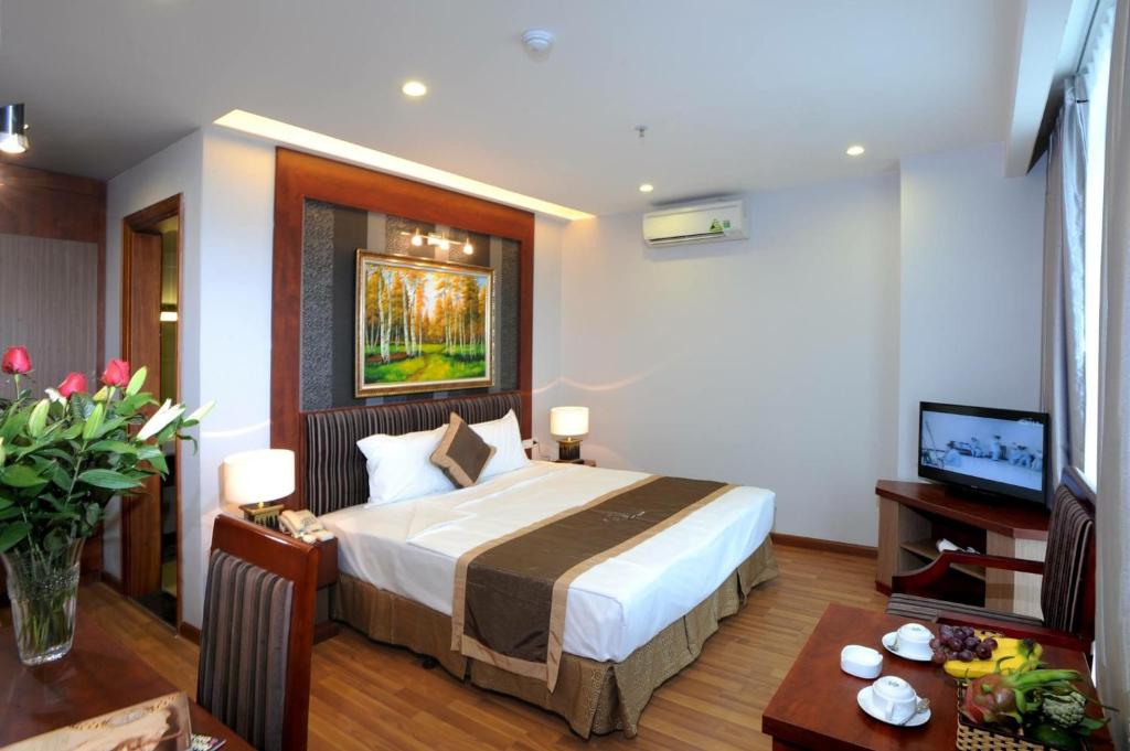 una camera d'albergo con letto e TV di Gallant Hotel a Hanoi