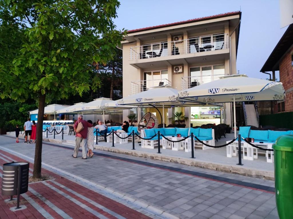 a group of tables with umbrellas in front of a building at Lago d'argento sobe in Veliko Gradište