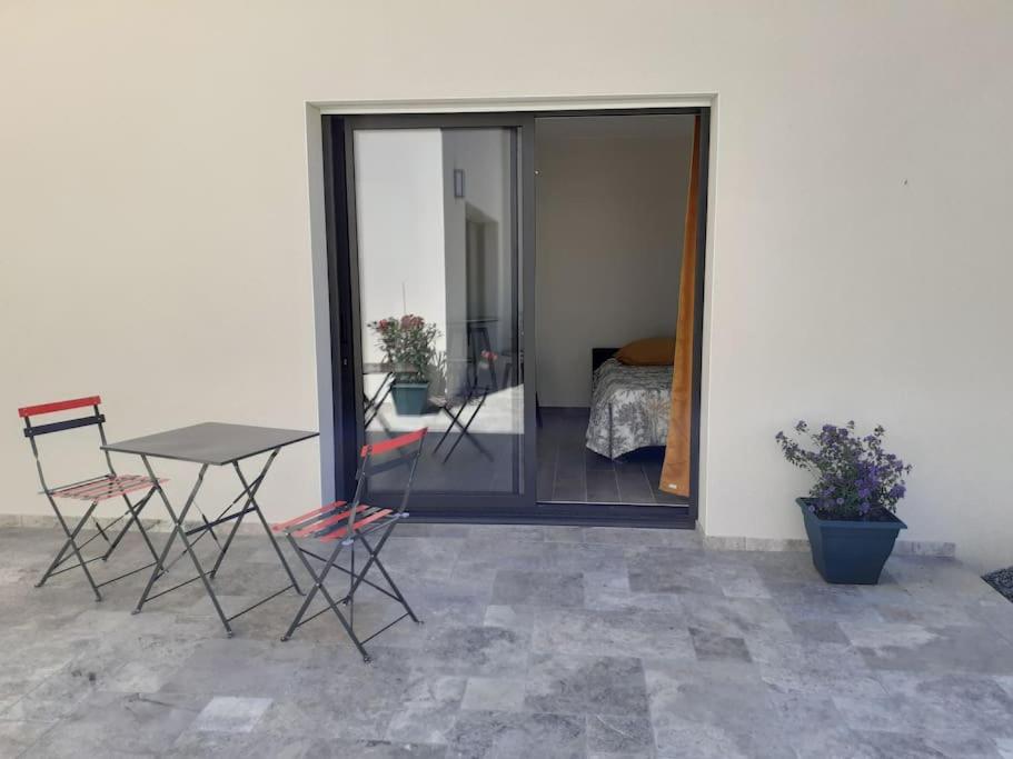 a patio with a table and chairs and a bed at chez Virginie et Jacky in Les Épesses