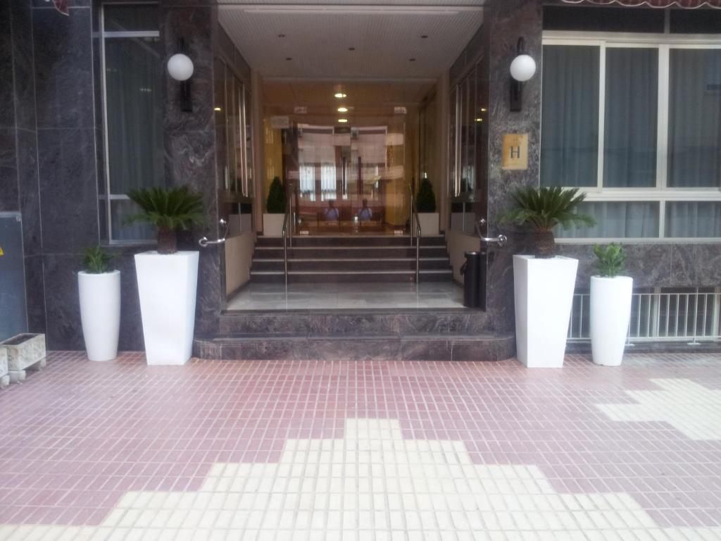 a lobby with potted plants in front of a building at Hotel Primavera in Benidorm