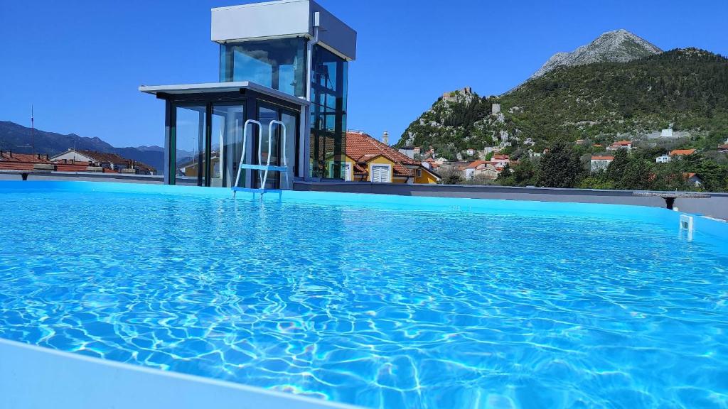 a swimming pool with blue water in front of a building at Hotel Prvan in Vrgorac
