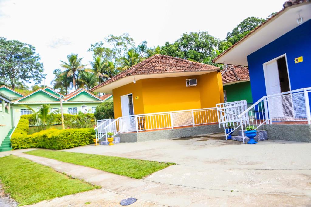 a yellow and blue house with a yard at Pousada Mama África in Conservatória