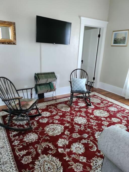ein Wohnzimmer mit 2 Stühlen und einem roten Teppich in der Unterkunft Historical Home in Guthrie